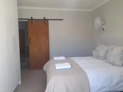 a bedroom with a bed with two towels on it at Cornerstone Guesthouse Drostdy in Panorama