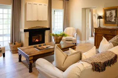 a living room with a couch and a fireplace at Grande Provence in Franschhoek