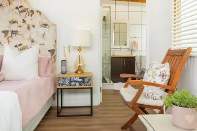 a bedroom with a bed and a chair at Studio 98 - 300m from cliff path in Hermanus