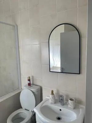 a bathroom with a toilet and a sink and a mirror at Beautiful 2 bedroom apartment in strand in Somerset West