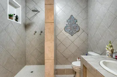 a bathroom with a shower with a toilet and a sink at Whale Watchers Gordons Bay in Gordonʼs Bay