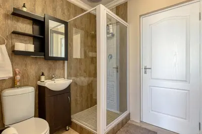 a bathroom with a shower and a toilet and a sink at Whale Watchers Gordons Bay in Gordonʼs Bay