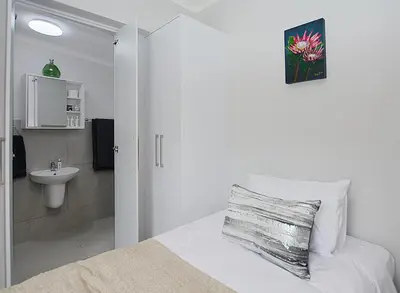 a bedroom with a bed with a sink and a toilet at Leetch Views - Budget Room in Cape Town