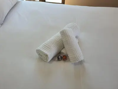 a white knitted toy on a white bed at Classy 3 storey house in Gordonʼs Bay