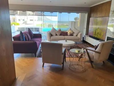 a living room with couches and a table and chairs at Classy 3 storey house in Gordonʼs Bay