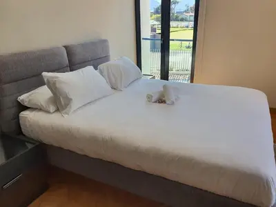 a teddy bear sitting on top of a bed at Classy 3 storey house in Gordonʼs Bay