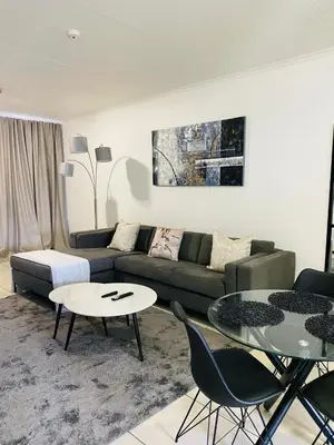 a living room with a couch and a table at Altin Pearl Luxury Apartment in Cape Town