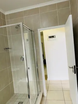 a bathroom with a shower with a glass door at Altin Pearl Luxury Apartment in Cape Town