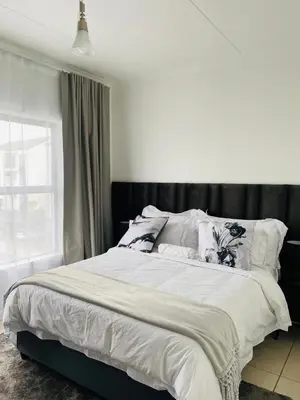 a bedroom with a large bed with white sheets and pillows at Altin Pearl Luxury Apartment in Cape Town