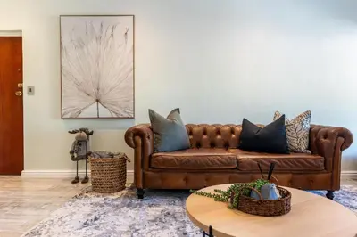 a living room with a brown couch and a table at Tweede Boom in Cape Town