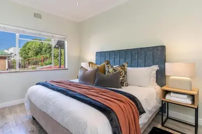 a bedroom with a large bed and a window at Tweede Boom in Cape Town