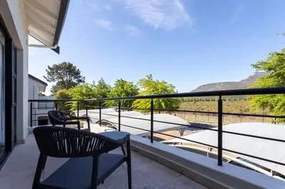 a balcony with chairs and a view of the mountains at Luxury Lodge 5B, Pearl Valley Golf Estate in Simondium