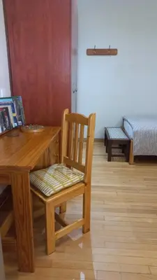 a wooden dining room table with a chair and a desk at 'The Cape Robin' studio apartment in Hoheizen
