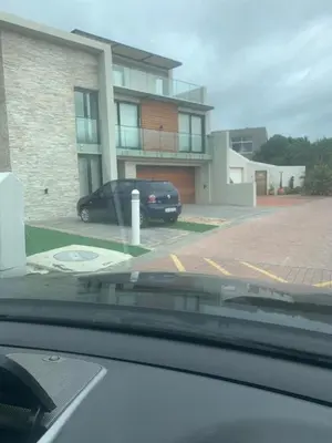 a car parked in a parking lot in front of a building at Classy 3 storey house in Gordonʼs Bay