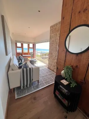 a living room with a couch and a mirror at Unique views Betties Bay in Bettyʼs Bay