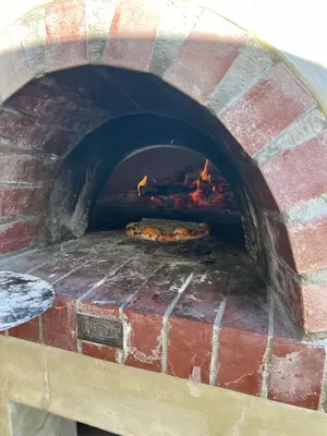 a brick oven with two pizzas in it at Unique views Betties Bay in Bettyʼs Bay