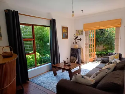 a living room with a couch and a table at A Jungle House in Somerset West