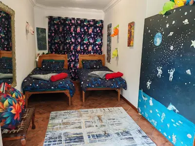 a room with two chairs and a wall with stars at A Jungle House in Somerset West