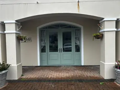 a front door of a house with two potted plants at 16 on Fernkloof in Hermanus