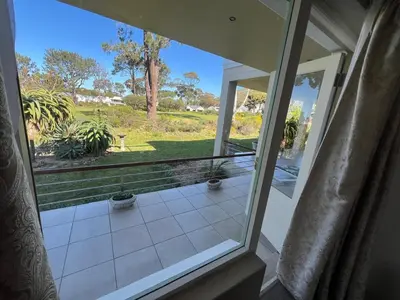 an open door to a porch with a view of a yard at 16 on Fernkloof in Hermanus