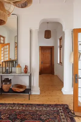 a hallway with a door and a table with a mirror at Hermanus Seafront Villa - Sophie's Rock in Hermanus