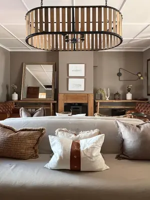 a room with a couch with pillows and a mirror at Hermanus Seafront Villa - Sophie's Rock in Hermanus