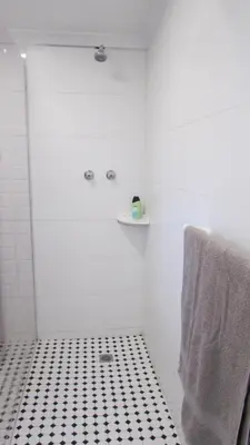 a bathroom with a black and white tiled floor at View Panoramica Self-Catering Apartment in Gordonʼs Bay