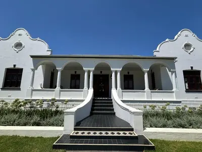 a white building with a staircase in front of it at Rooiheuwel in Botrivier