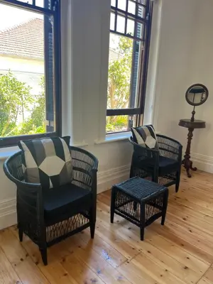 two chairs and a table in a room with windows at The Alma House 1900 in Cape Town
