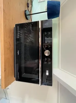 a microwave oven hanging on a wall in a kitchen at The Studio - a lovely 1 bed loft apartment in Somerset West