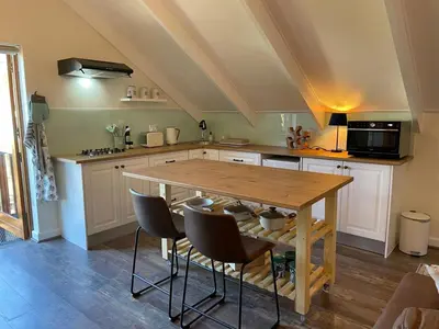 a kitchen with a wooden table and chairs at The Studio - a lovely 1 bed loft apartment in Somerset West