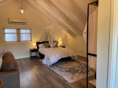 a bedroom with a bed with a canopy at The Studio - a lovely 1 bed loft apartment in Somerset West