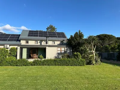 a house with solar panels on the roof at The Cottage - a tranquil hideaway in Somerset West