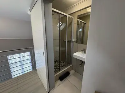 a bathroom with a shower and a sink at Stylish Loft apartment in the heart of Durbanville in Durbanville