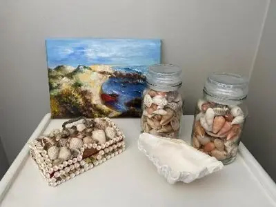 a shelf with two jars of rocks and a painting at Lawaaiwaters in Hermanus