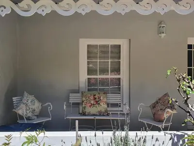 two chairs sitting in a room with a window at Charming Rose Cottage in Greyton