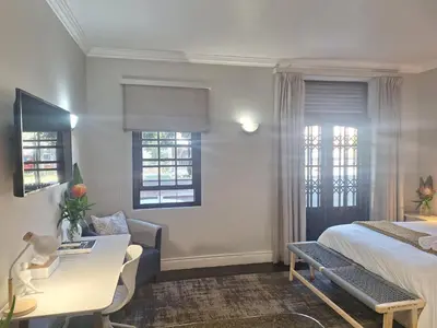a hotel room with a bed and a desk at Studio in Central Stellenbosch in Stellenbosch