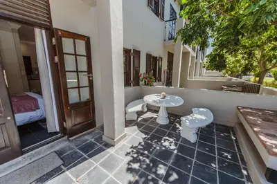 a patio with a table and a table and a door at Studio in Central Stellenbosch in Stellenbosch
