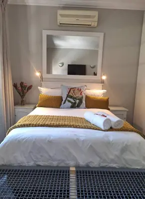 a bedroom with a large bed with a large mirror at Studio in Central Stellenbosch in Stellenbosch