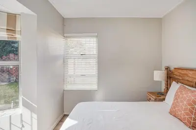 a white bedroom with a bed and a window at Villa Franlisa in Hermanus