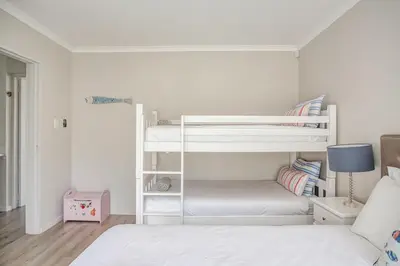 a bedroom with two bunk beds and a bed at Villa Franlisa in Hermanus