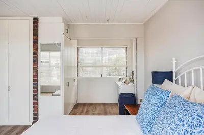 a bedroom with a bed with blue and white pillows at Villa Franlisa in Hermanus