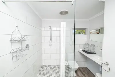 a white bathroom with a shower and a sink at Infinite Studio str in Panorama