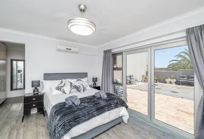 a white bedroom with a bed and a balcony at Infinite Studio str in Panorama
