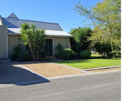 a house with a gravel driveway in front of a house at De Kleine Herberg in Durbanville