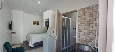 a bathroom with a bed and a sink in a room at Twinex Accommodation Parow in De Grendel