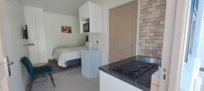 a kitchen with a sink and a bedroom with a bed at Twinex Accommodation Parow in De Grendel