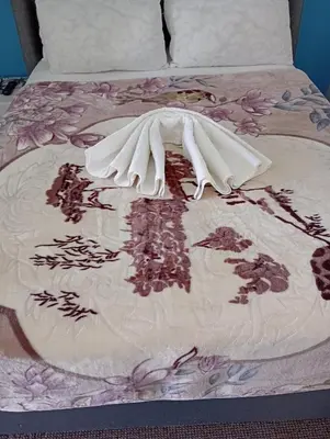 a bed with a blanket on top of it at Twinex Accommodation Bellville in Stikland