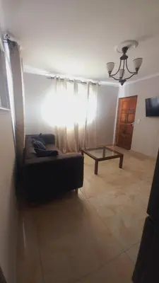 a living room with a couch and a table at Zoe Apartment in Cape Town