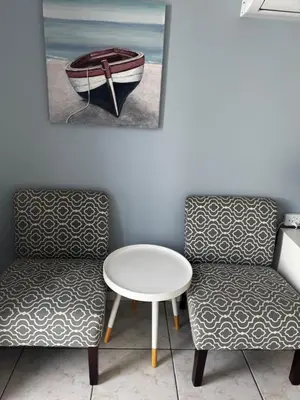two chairs and a table and a boat on the wall at Pemba Guest Cape Town in Cape Town